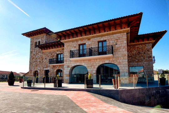Un hotel de piedras con grandes ventanales y balcones. Un lugar ideal para dormir cerca de Cabárceno.