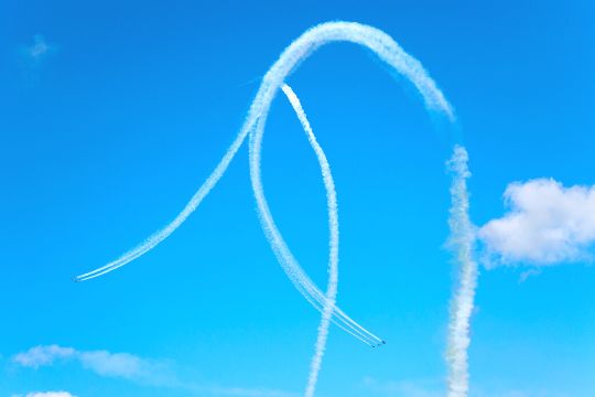 cinco aviones están realizando maniobras aéreas en un cielo parcialmente despejado gracias a su regalo de vuelo acrobático.