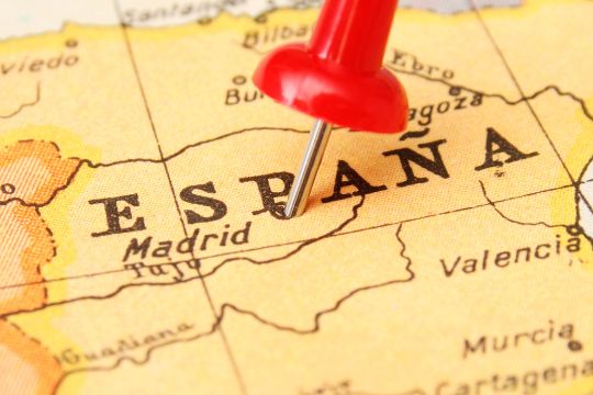 Un mapa de España con una chincheta roja clavada en Madrid, para su viaje de relax.