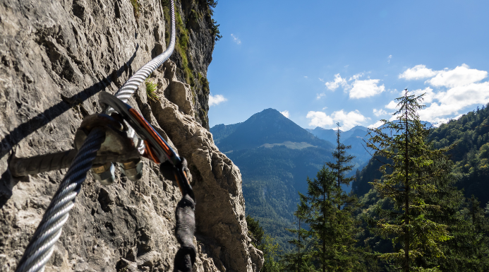 montaña con una cuerda y eslabones representando que es una vía ferrata