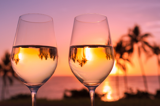 dos copas en la playa representando una escapada romántica barata