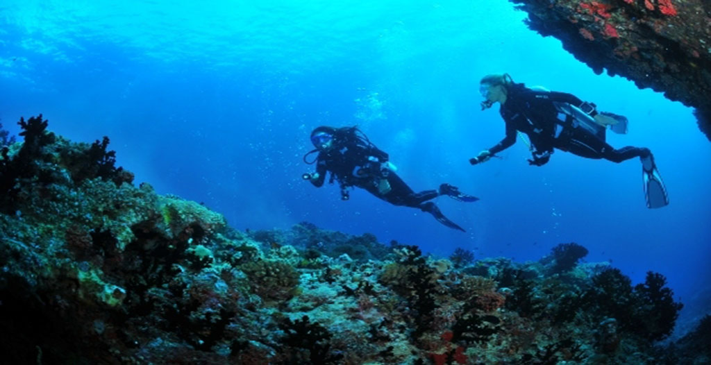 En la imagen se muestra una pareja disfrutando de su escapada romántica al País Vasco, realizando una inmersión de buceo junto a Buceo Hondarribia. 