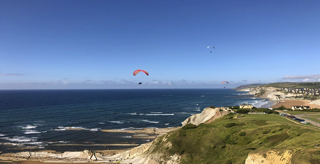 Un grupo de personas disfrutando de los paisajes del pueblo y mar de Getxo, con los chicos de Parapente Getxo. 