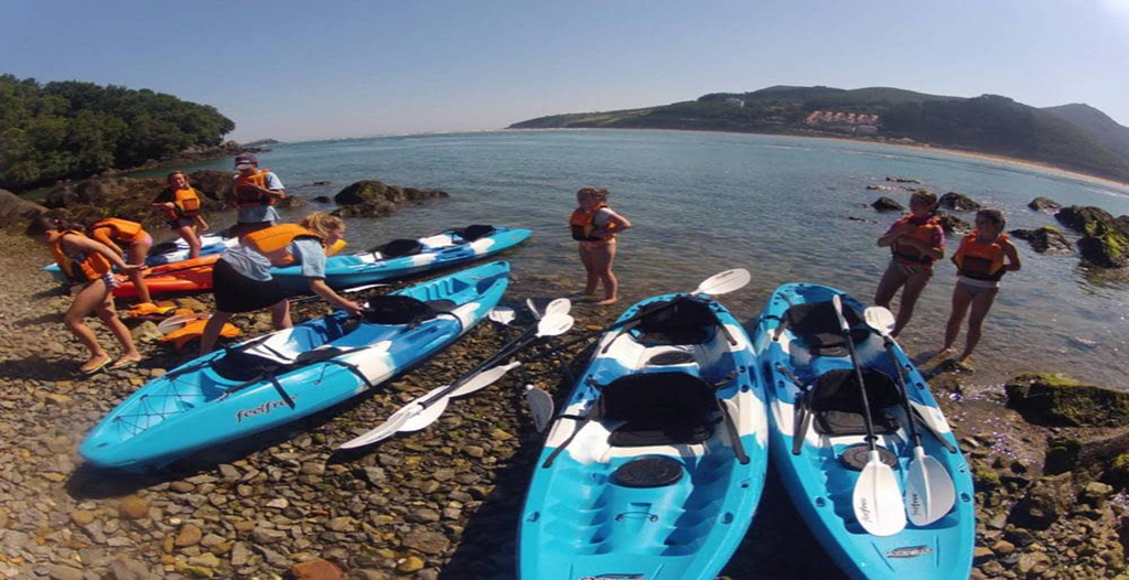 En la imagen se muestra a un grupo de amigos y familiares disfrutando de una experiencia en kayaks en la reserva de Urdaibai, junto a la compañía Urdaibai Kiroleroak.  