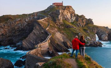 En la imagen se muestra una pareja, disfrutando de su escápada romántica en el País vasco en frente de la isla de San Juan de Gaztelugatxe.